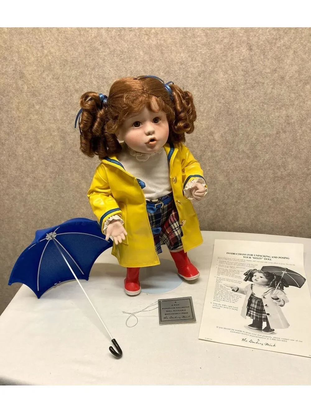 The Danbury Mint 'Kelly' Porcelain Doll with Blue Umbrella and Yellow Raincoat